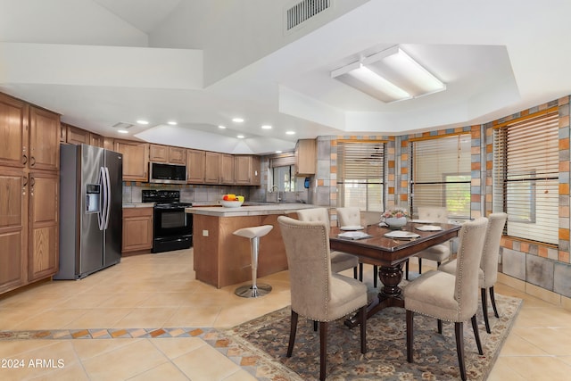 tiled dining area with a raised ceiling and sink