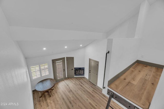 entrance foyer featuring a fireplace, light hardwood / wood-style flooring, and lofted ceiling