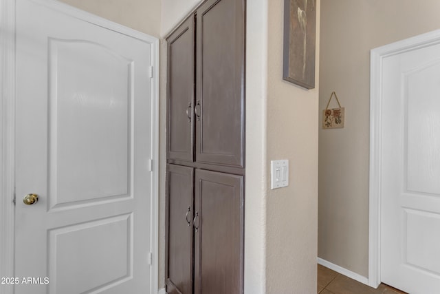 hall with dark tile patterned flooring