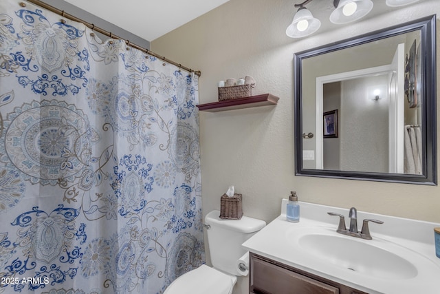 bathroom featuring curtained shower, vanity, and toilet