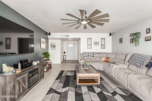 living room with light hardwood / wood-style floors and ceiling fan