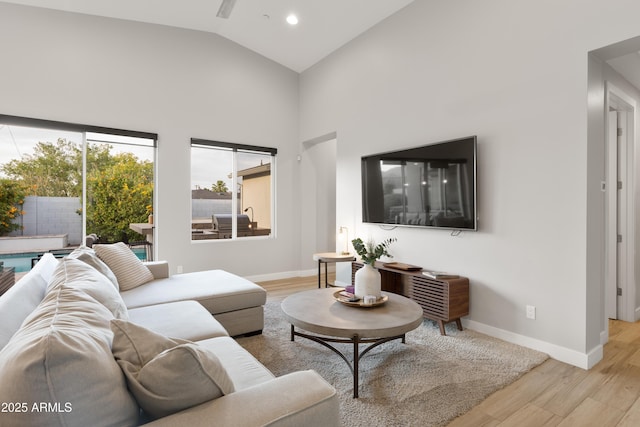 6450 E Vernon Ave, Scottsdale, AZ 85257 - living room featuring light wood-type flooring, baseboards, high vaulted ceiling, and recessed lighting
