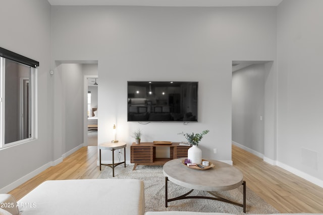 6450 E Vernon Ave, Scottsdale, AZ 85257 - living room with light wood finished floors, a towering ceiling, and baseboards