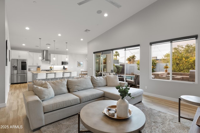 6450 E Vernon Ave, Scottsdale, AZ 85257 - living room featuring recessed lighting, baseboards, light wood finished floors, and high vaulted ceiling
