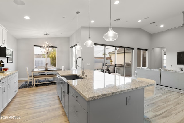 6450 E Vernon Ave, Scottsdale, AZ 85257 - kitchen with a sink, light wood-type flooring, an island with sink, white cabinets, and a chandelier