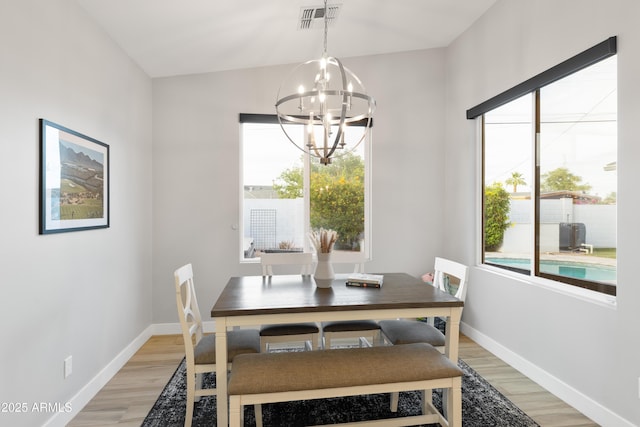 6450 E Vernon Ave, Scottsdale, AZ 85257 - dining area featuring a chandelier, light wood-style flooring, and baseboards