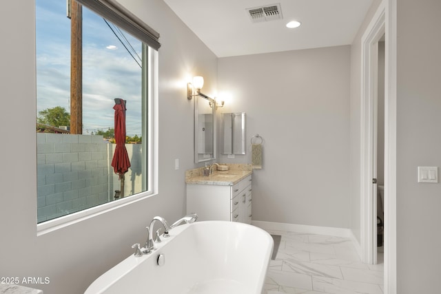 6450 E Vernon Ave, Scottsdale, AZ 85257 - full bath with a freestanding tub, marble look tile flooring, plenty of natural light, vanity, and recessed lighting