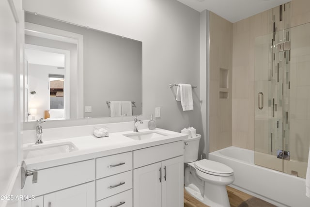 6450 E Vernon Ave, Scottsdale, AZ 85257 - ensuite bathroom featuring double vanity, toilet, bath / shower combo with glass door, and wood finished floors