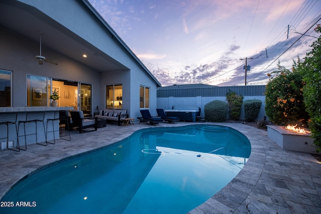 6450 E Vernon Ave, Scottsdale, AZ 85257 - pool at dusk with an outdoor living space with a fire pit, a patio, and ceiling fan