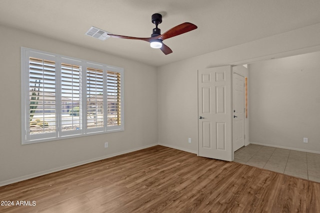 empty room featuring light wood-type flooring and ceiling fan