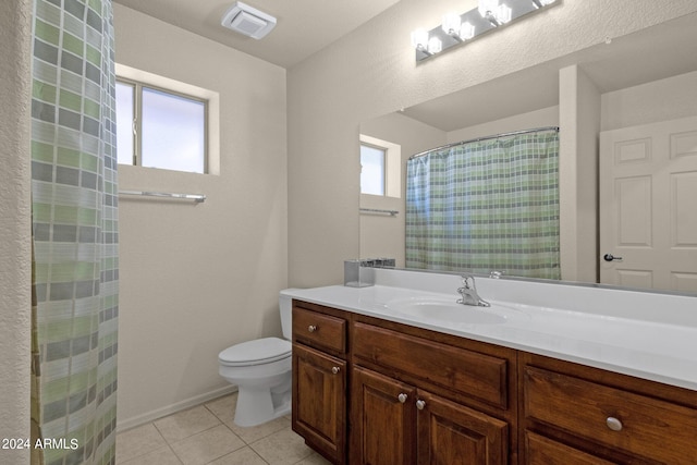 bathroom with vanity, tile patterned floors, toilet, and a healthy amount of sunlight