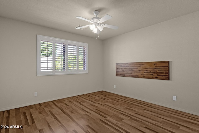 unfurnished room with ceiling fan, wood-type flooring, and a textured ceiling