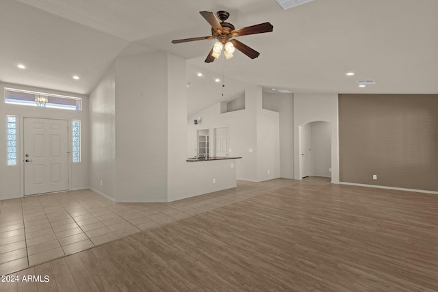 interior space with light wood-type flooring, high vaulted ceiling, and ceiling fan