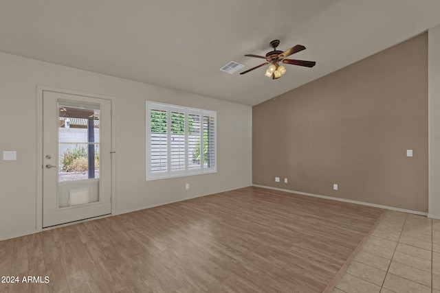 spare room with light hardwood / wood-style floors, vaulted ceiling, and ceiling fan