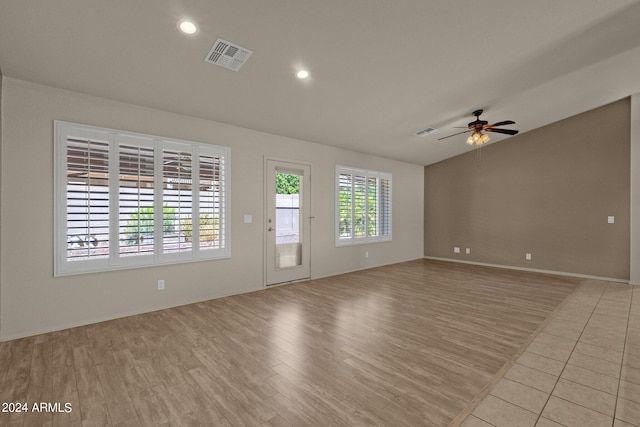 spare room with ceiling fan, light wood-type flooring, and lofted ceiling