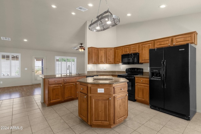 kitchen featuring ceiling fan, kitchen peninsula, a kitchen island, decorative light fixtures, and black appliances