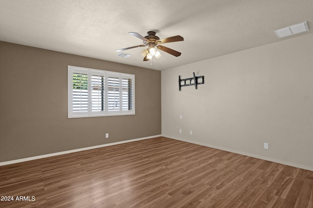 spare room featuring ceiling fan, dark hardwood / wood-style floors, and a textured ceiling