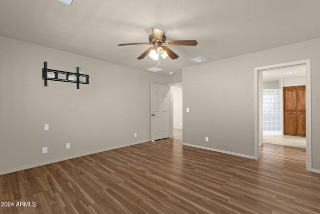 unfurnished room featuring ceiling fan, a textured ceiling, and dark hardwood / wood-style floors