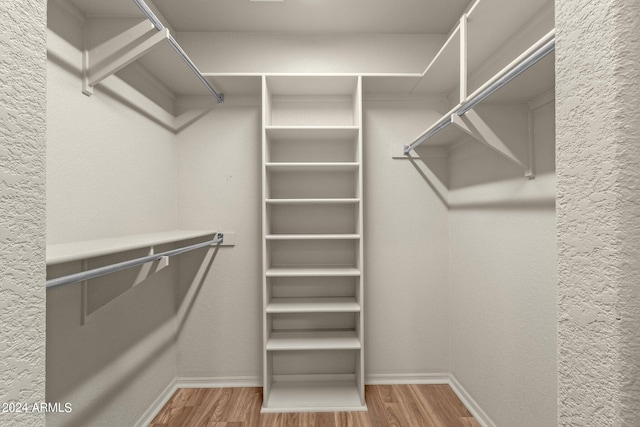 walk in closet with hardwood / wood-style floors