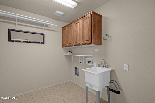 clothes washing area with electric dryer hookup, washer hookup, light tile patterned floors, and cabinets