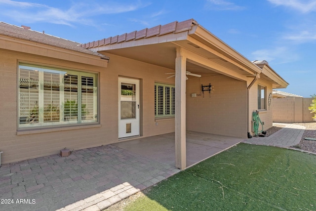 back of property with a patio, a yard, and ceiling fan