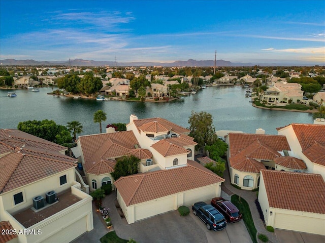 drone / aerial view with a water and mountain view and a residential view