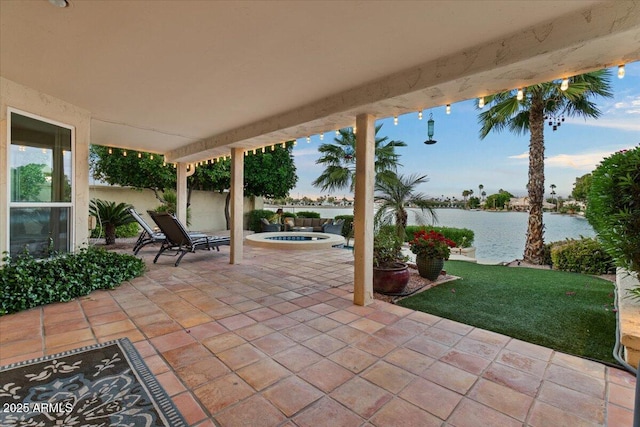 view of patio featuring fence and a water view