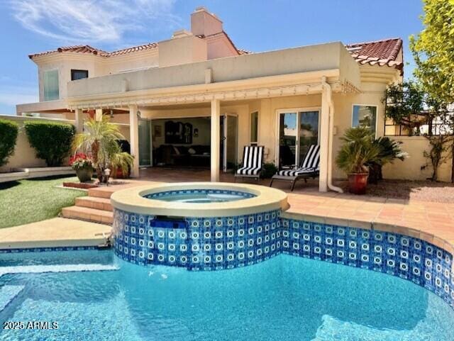 back of house featuring stucco siding, a patio area, fence, and a pool with connected hot tub