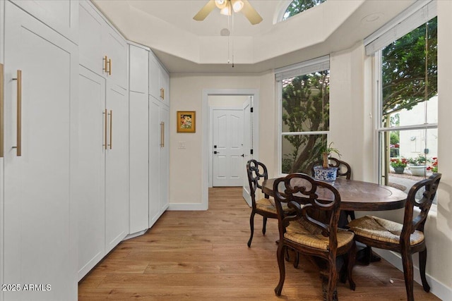 dining room featuring light wood-style floors, baseboards, and ceiling fan