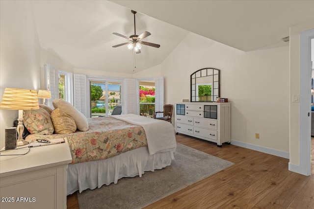 bedroom with a ceiling fan, baseboards, wood finished floors, and high vaulted ceiling
