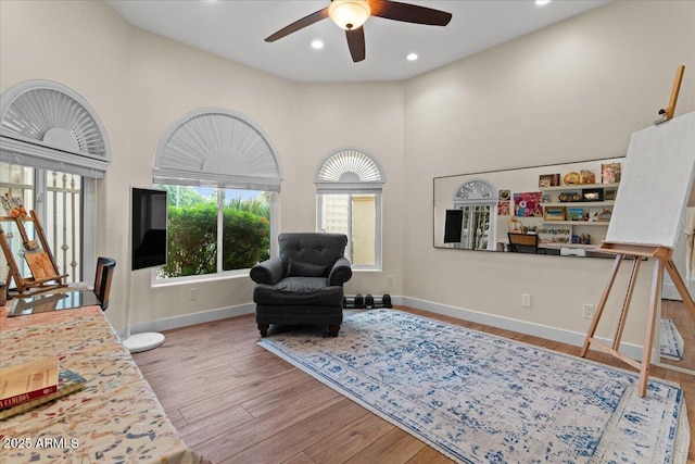 bedroom with baseboards, wood finished floors, and multiple windows