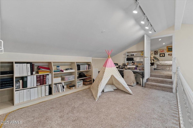 recreation room featuring carpet floors, vaulted ceiling, and track lighting