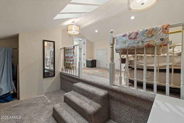 stairway with carpet flooring and lofted ceiling with skylight