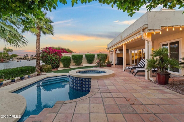 view of pool featuring a water view, an in ground hot tub, a fenced in pool, and a patio area
