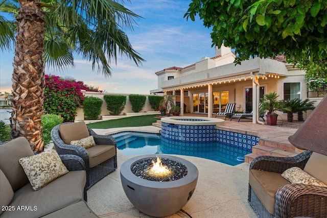 view of swimming pool featuring a patio, an in ground hot tub, a fenced in pool, and an outdoor fire pit