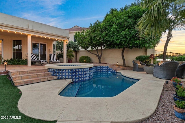 pool at dusk featuring a fenced backyard, a fenced in pool, a patio, and an in ground hot tub
