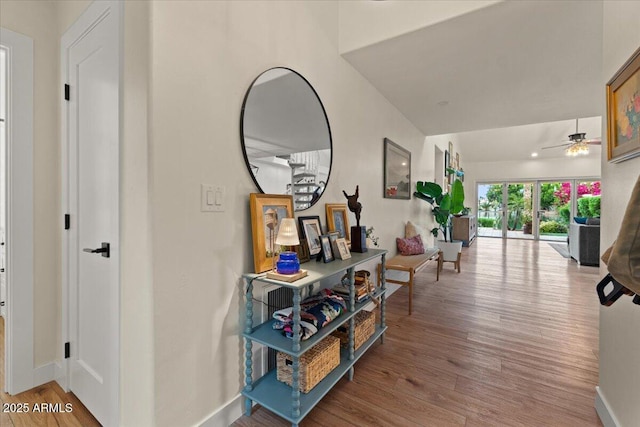 corridor featuring baseboards and wood finished floors