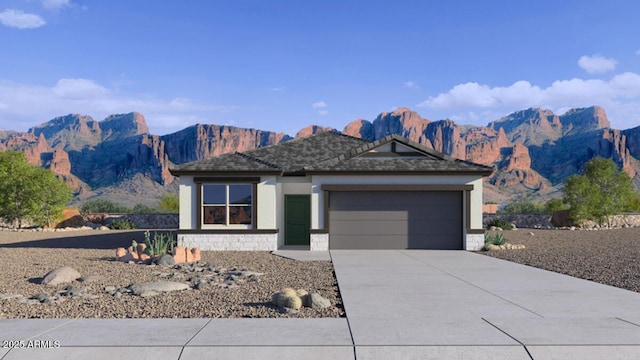 view of front of house featuring driveway, a garage, a mountain view, and stucco siding