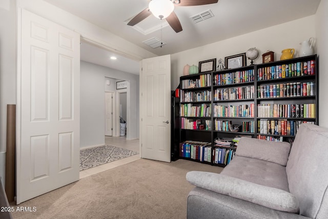 sitting room featuring visible vents, carpet, and a ceiling fan