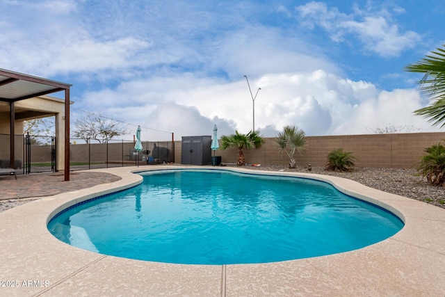 view of pool featuring an outbuilding, a fenced in pool, a storage shed, and a fenced backyard