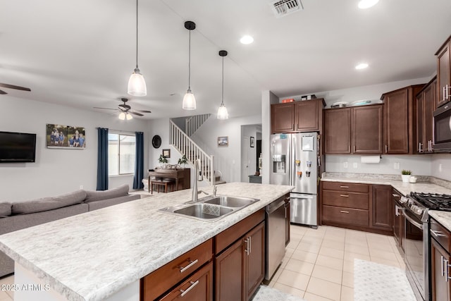 kitchen featuring visible vents, ceiling fan, open floor plan, appliances with stainless steel finishes, and a sink