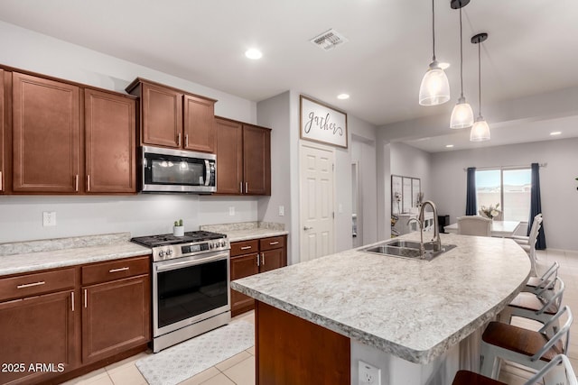 kitchen with a sink, visible vents, appliances with stainless steel finishes, and light countertops