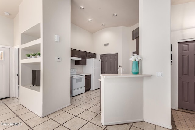14216 N Saguaro Blvd Unit A, Fountain Hills, AZ 85268 - kitchen with a peninsula, light tile patterned flooring, white appliances, high vaulted ceiling, and light countertops