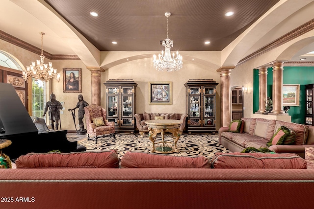 living room with crown molding, a chandelier, and decorative columns