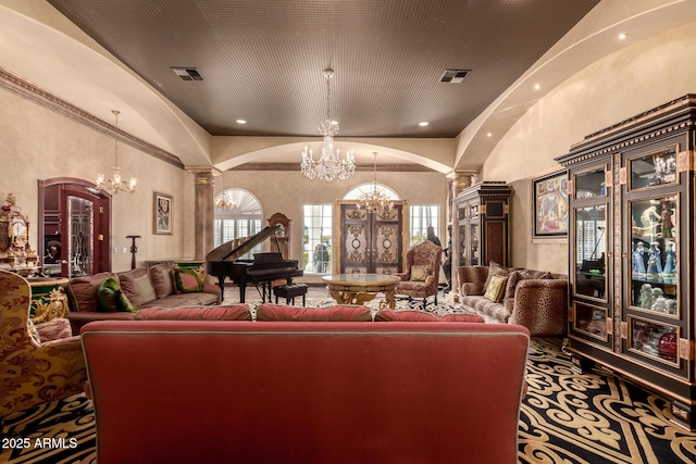 carpeted living room with ornate columns, a high ceiling, a chandelier, and french doors