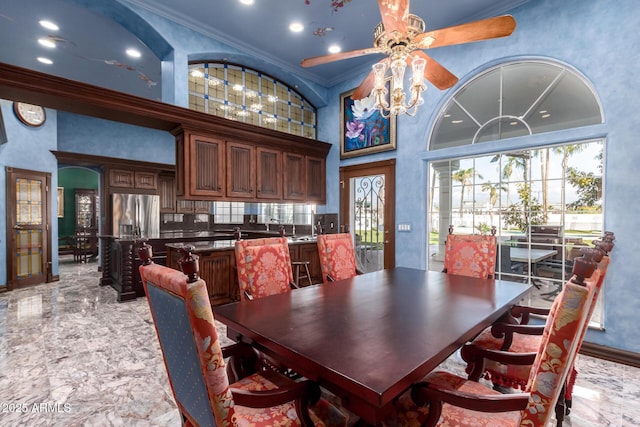 dining space featuring crown molding, ceiling fan, and a high ceiling