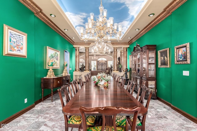 dining room with a raised ceiling, ornamental molding, decorative columns, and a chandelier