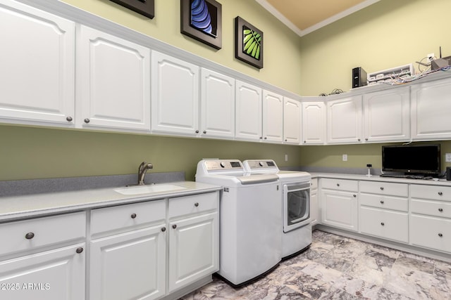 laundry area with sink, ornamental molding, cabinets, and washing machine and clothes dryer