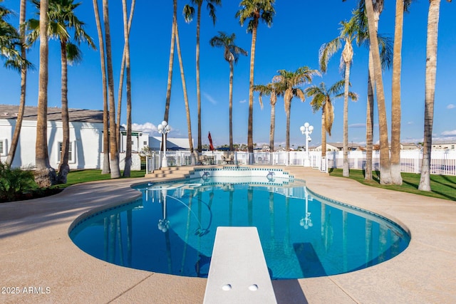 view of pool with a diving board and a patio area