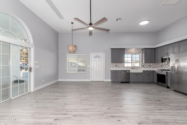 kitchen featuring gray cabinets, sink, decorative backsplash, stainless steel appliances, and light hardwood / wood-style flooring